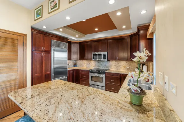 a kitchen with stainless steel appliances granite countertop sink stove and granite counter top