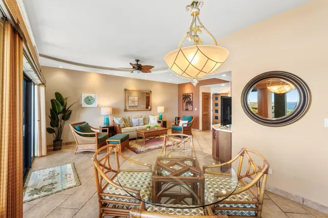 a living room with a dining table a mirror and a chandelier