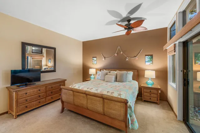 a bedroom with a bed and a flat tv screen on dresser