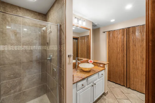 a bathroom with a granite countertop sink and a mirror