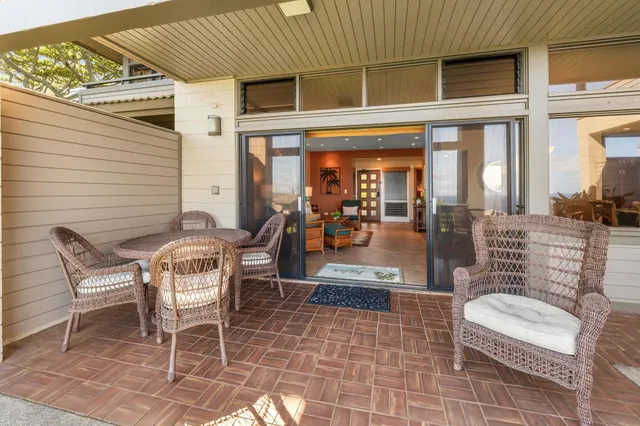 a view of a patio with table and chairs with wooden floor and fence