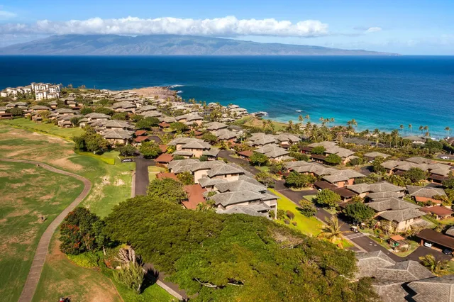 a view of a city with lots of residential buildings ocean and mountain view in back