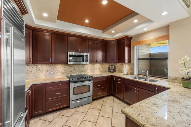 a kitchen with stainless steel appliances granite countertop wooden cabinets a stove top oven a sink and dishwasher