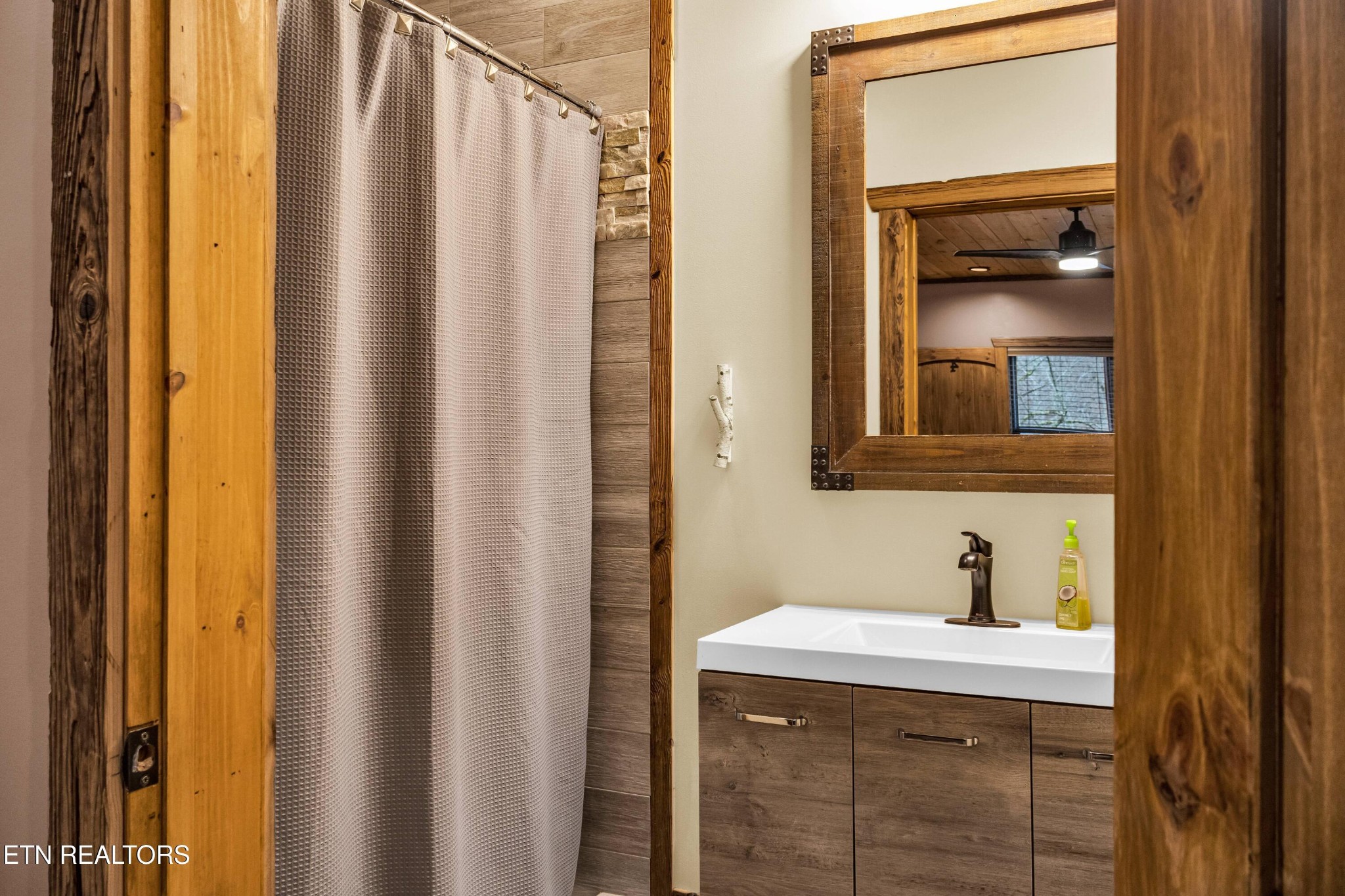 173 Rafter Road Tellico Plains, TN 37385 - Photo 31 of 49 a bathroom with a sink a mirror and a window