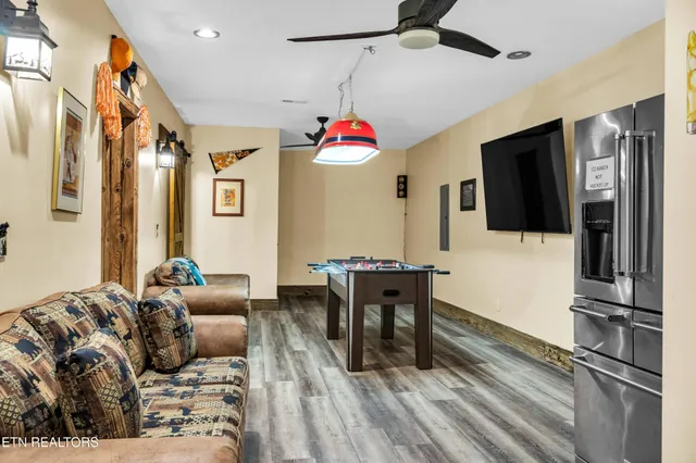 a living room with furniture a flat screen tv and a chandelier