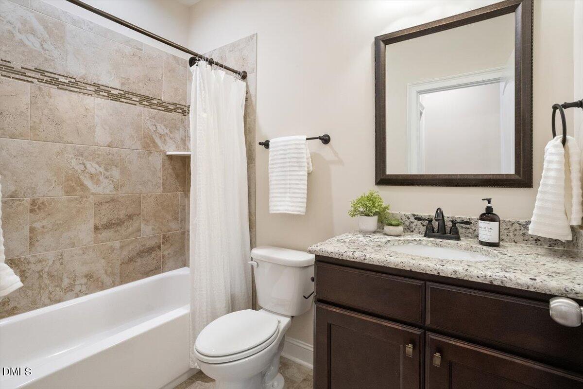 1321 Cedar Grove Road Pittsboro, NC 27312 - Photo 76 of 82 a bathroom with a granite countertop sink toilet a mirror and shower
