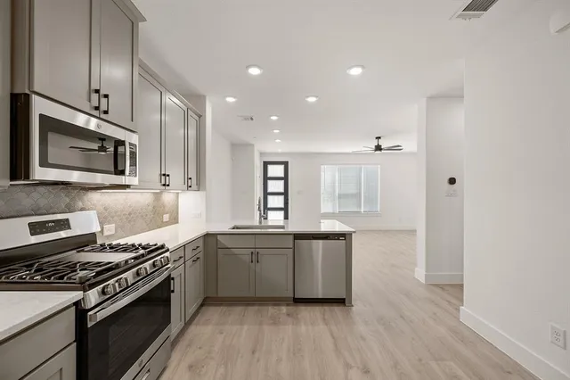 a kitchen with stainless steel appliances granite countertop a sink stove and cabinets