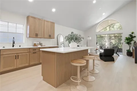 a kitchen with stainless steel appliances a sink a stove a refrigerator cabinets and dining table