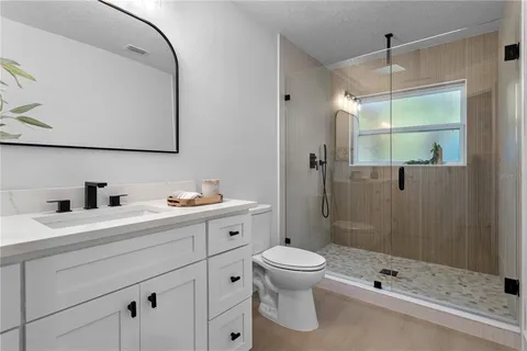 a bathroom with a sink a toilet and shower