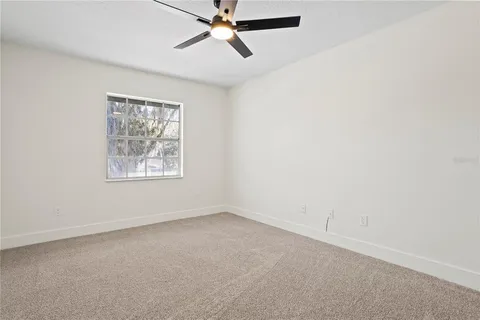 an empty room with a window and a fan