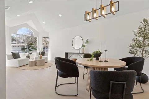 a dining room with furniture a chandelier and kitchen view