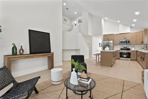 a living room with furniture kitchen view and a potted plant