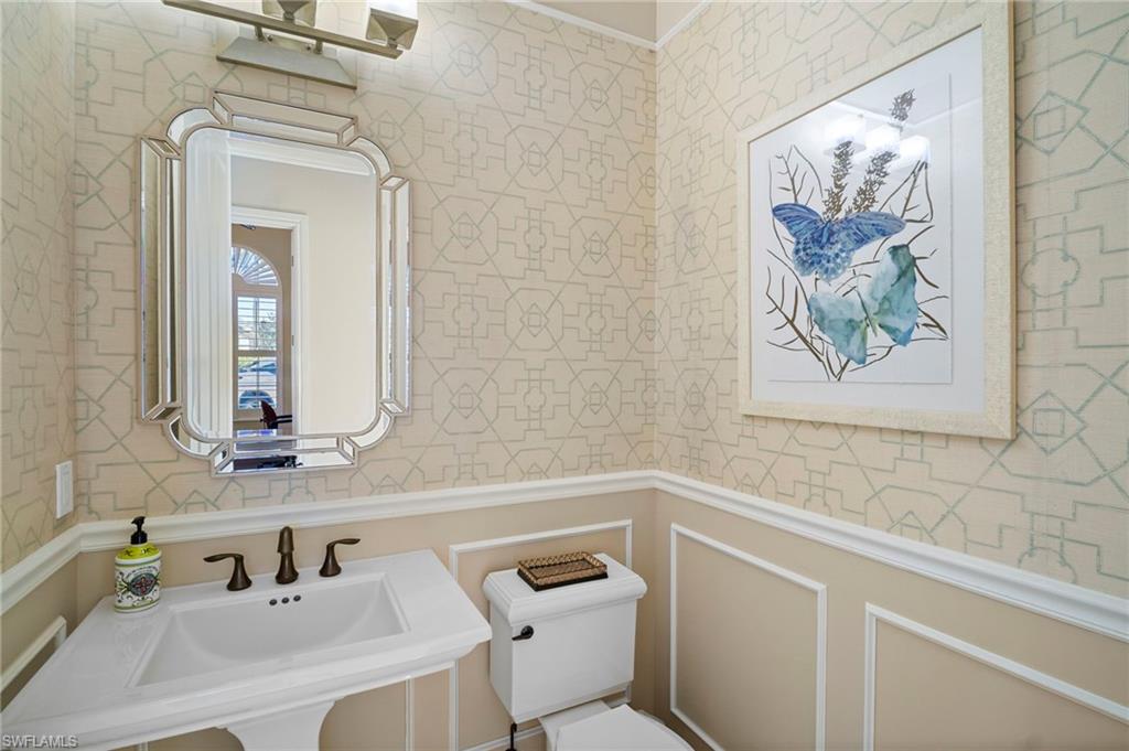 6482 Carema Lane Naples, FL 34113 - Photo 13 of 40 a bathroom with a toilet a sink and mirror