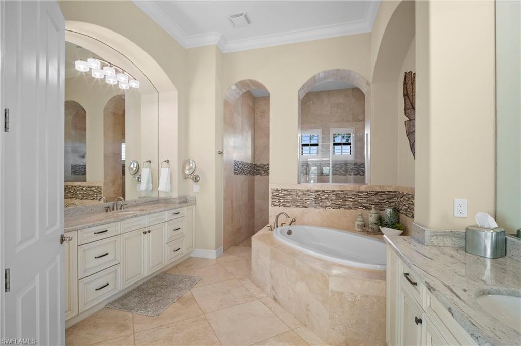 6482 Carema Lane Naples, FL 34113 - Photo 16 of 40 a bathroom with a granite countertop sink a mirror a bathtub and a shower