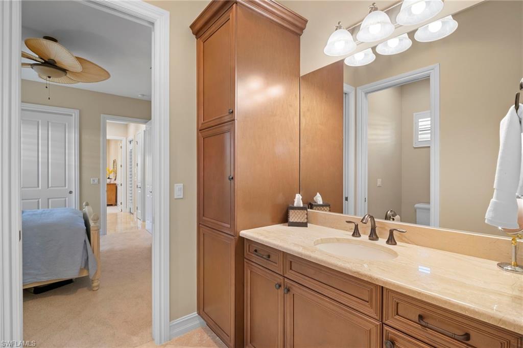 6482 Carema Lane Naples, FL 34113 - Photo 21 of 40 a en suite bathroom with a granite countertop sink a light fixture and a mirror