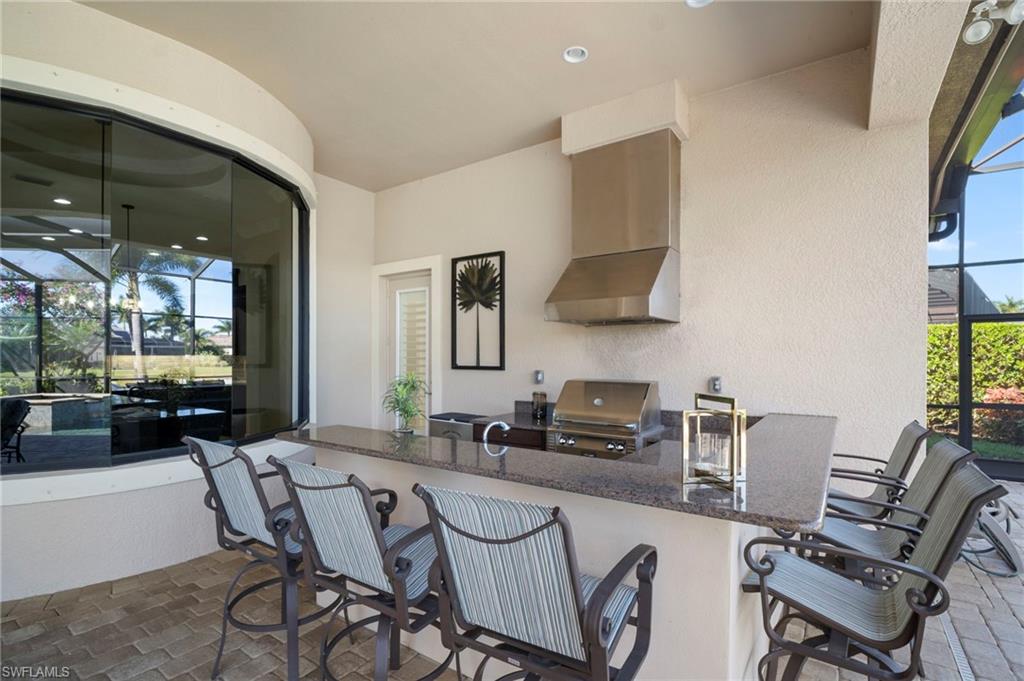 6482 Carema Lane Naples, FL 34113 - Photo 29 of 40 a dining room with furniture and a flat screen tv