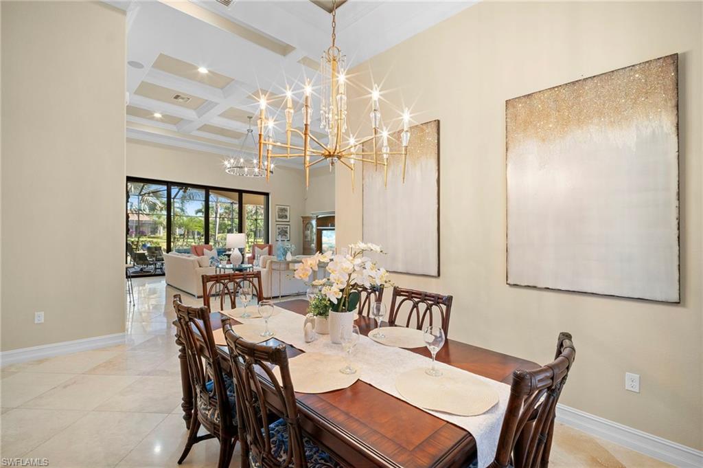 6482 Carema Lane Naples, FL 34113 - Photo 7 of 40 a dining room with furniture a chandelier and wooden floor