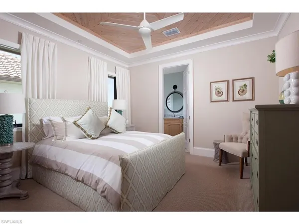 a bedroom with a large bed and a chandelier