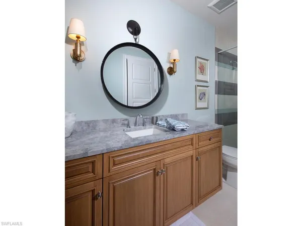 a bathroom with a granite countertop double vanity sink and a mirror