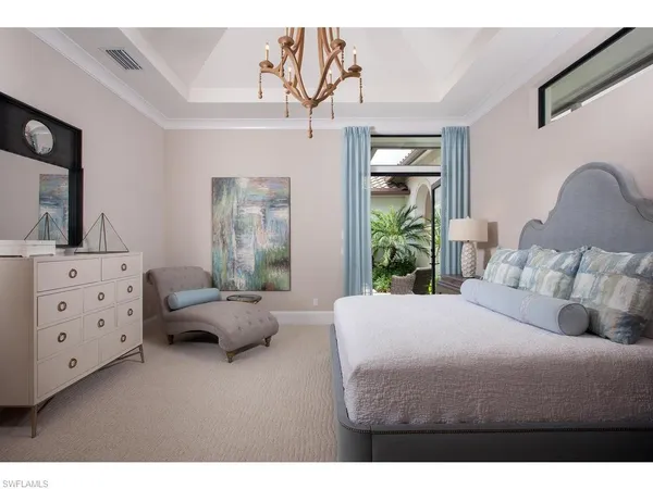 a bedroom with a bed and large windows