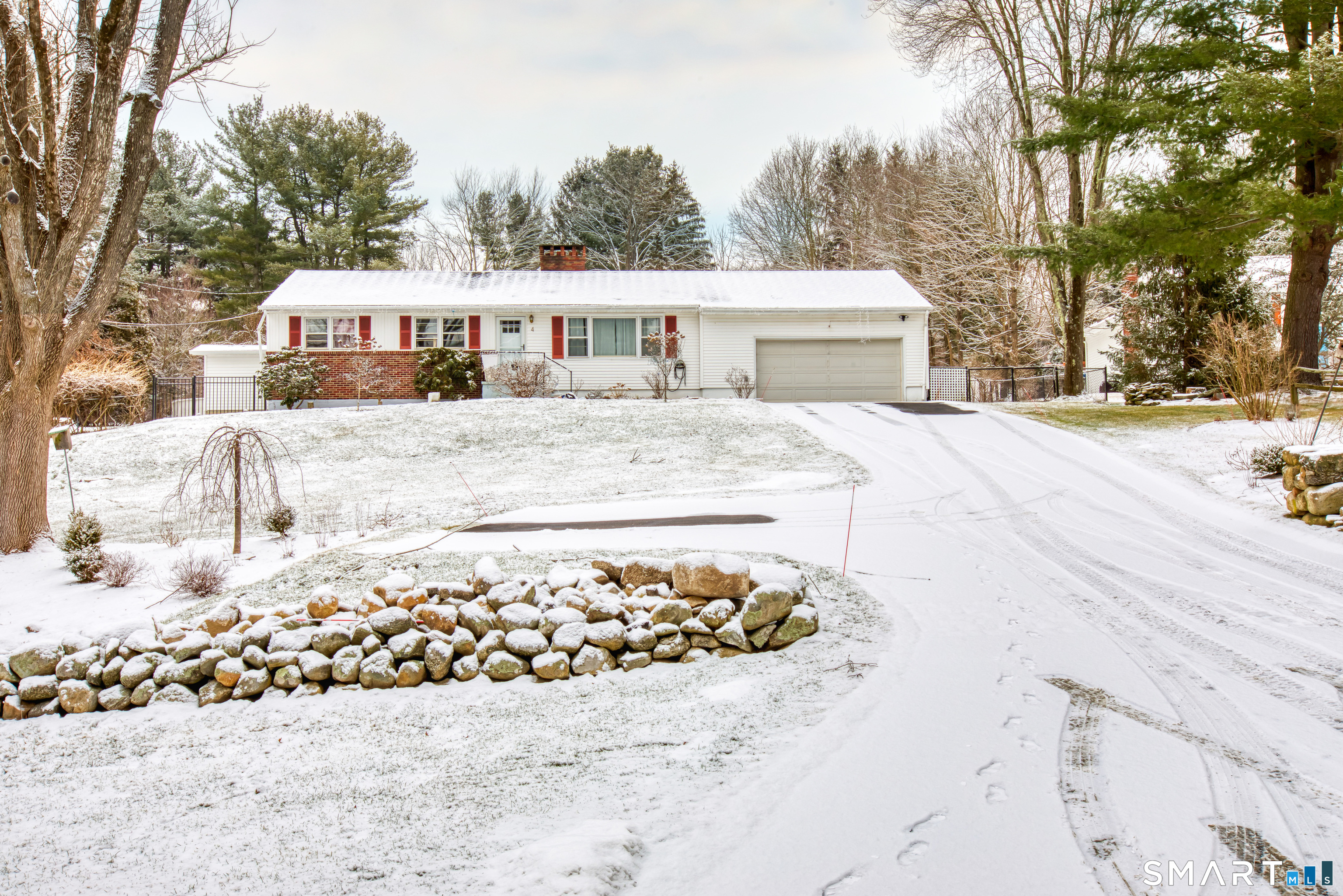a front view of a house with a yard covered with snow