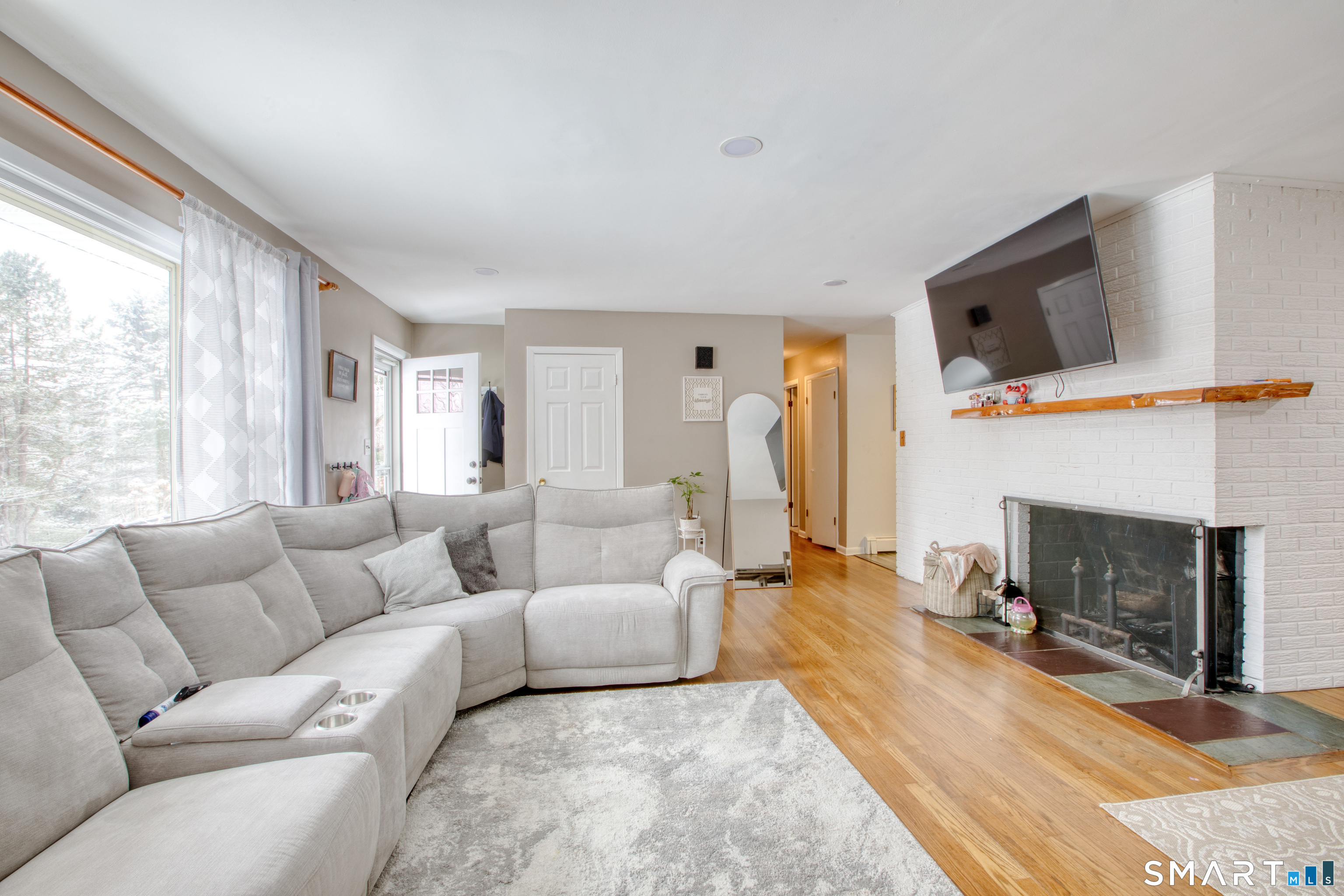 4 Edmond Road Bethel, CT 06801 - Photo 25 of 40 a living room with furniture a fireplace and a flat screen tv