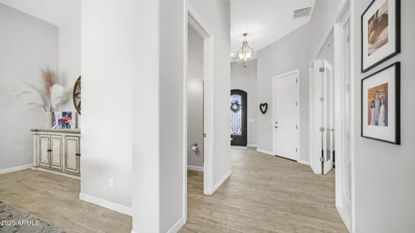 a dining room with furniture a chandelier and wooden floor