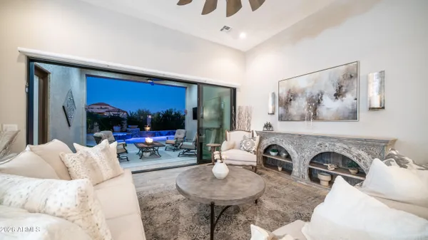 a living room with furniture kitchen view and a large window