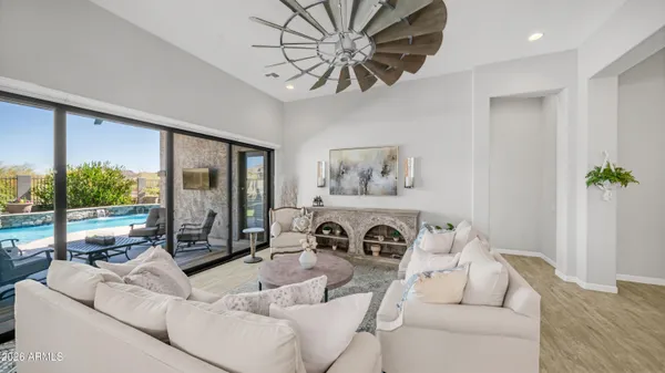 a kitchen with stainless steel appliances kitchen island granite countertop a dining table chairs and a refrigerator