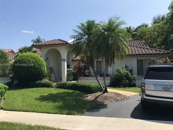 a front view of a house with a yard and potted plants