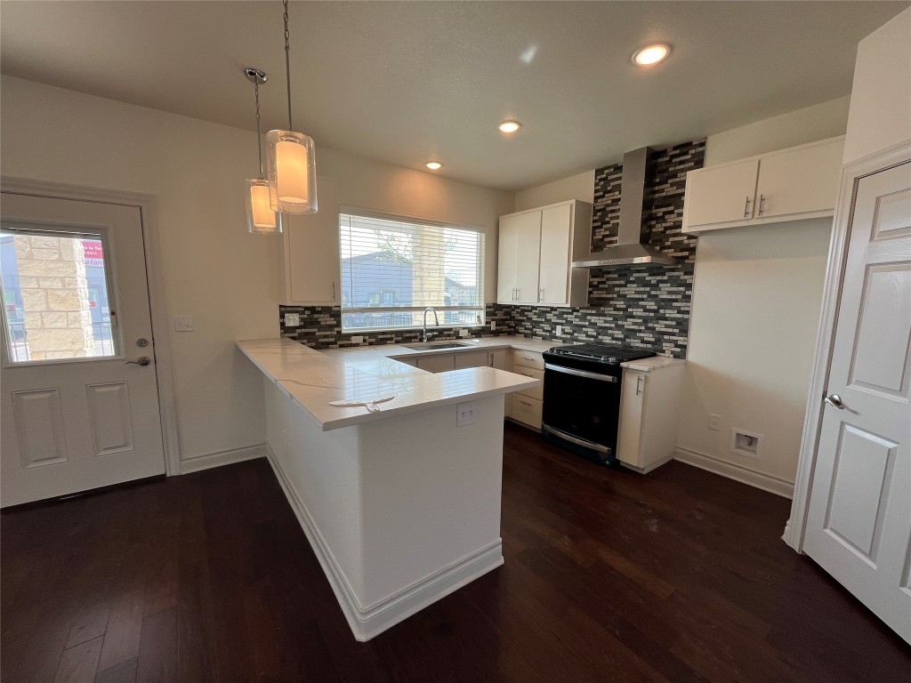 2105 Tiger Trail, Unit 501 Round Rock, TX 78664 - Photo 3 of 10 a kitchen with stainless steel appliances granite countertop a sink a stove a refrigerator a center island with wooden floor and cabinets