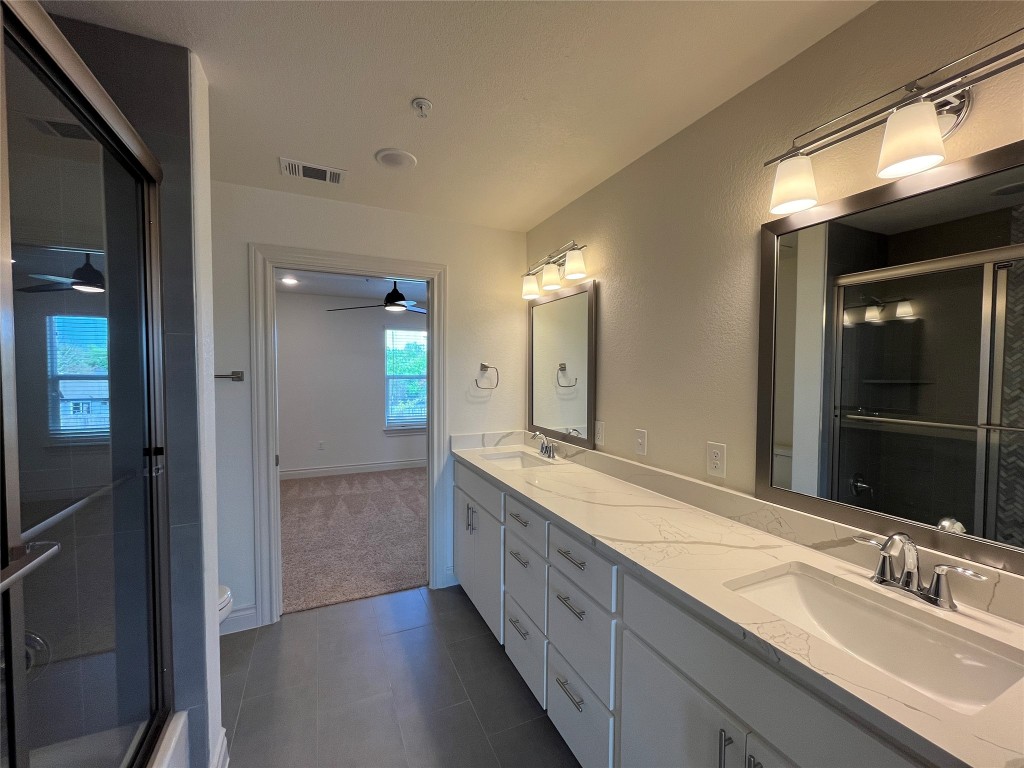 2105 Tiger Trail, Unit 501 Round Rock, TX 78664 - Photo 9 of 10 a bathroom with a double vanity sink and a mirror