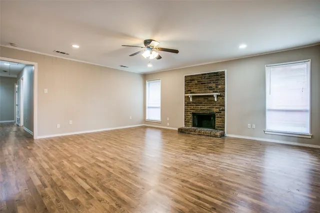 a view of an empty room with a fireplace and a window