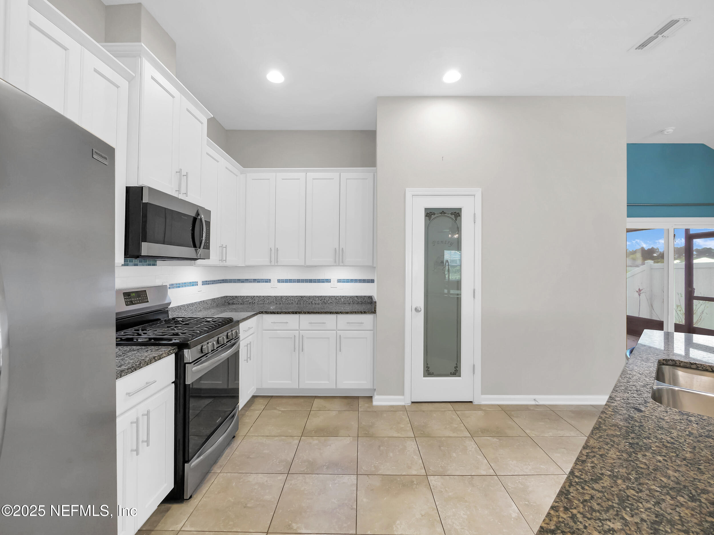 258 Fox Water Trail St. Augustine, FL 32086 - Photo 21 of 50 a kitchen with stainless steel appliances granite countertop a stove top oven microwave and refrigerator