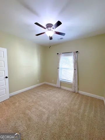 en empty room with windows and ceiling fan