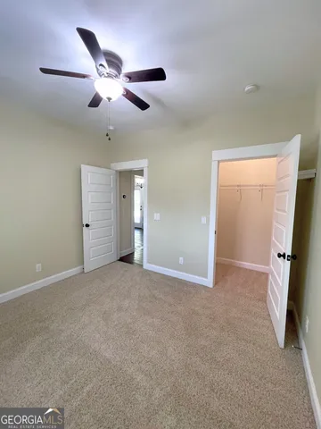 a view of a livingroom with a ceiling fan and window