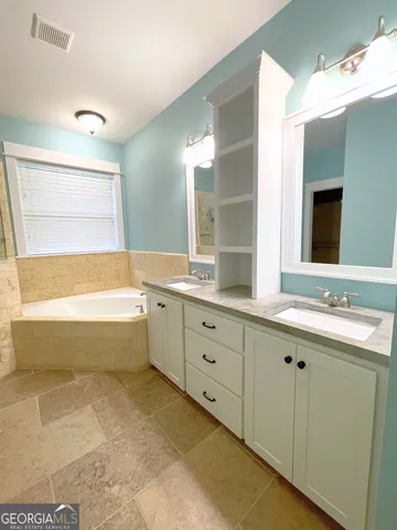 a bathroom with a bathtub sink and mirror