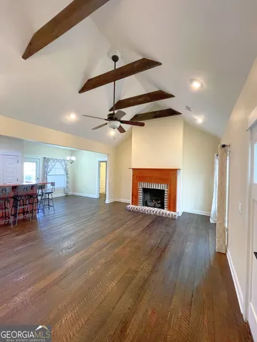 a view of empty room with wooden floor and fireplace