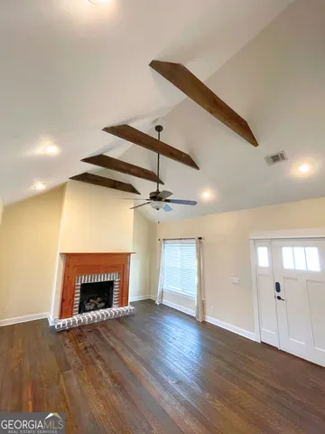 a view of empty room with wooden floor and fireplace