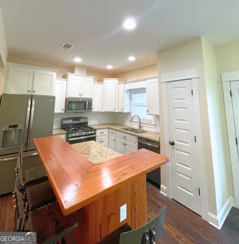 a kitchen with a refrigerator a stove a sink and a stove