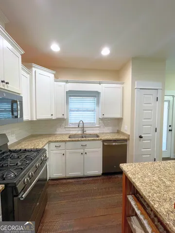 a kitchen with granite countertop cabinets stainless steel appliances and a counter space