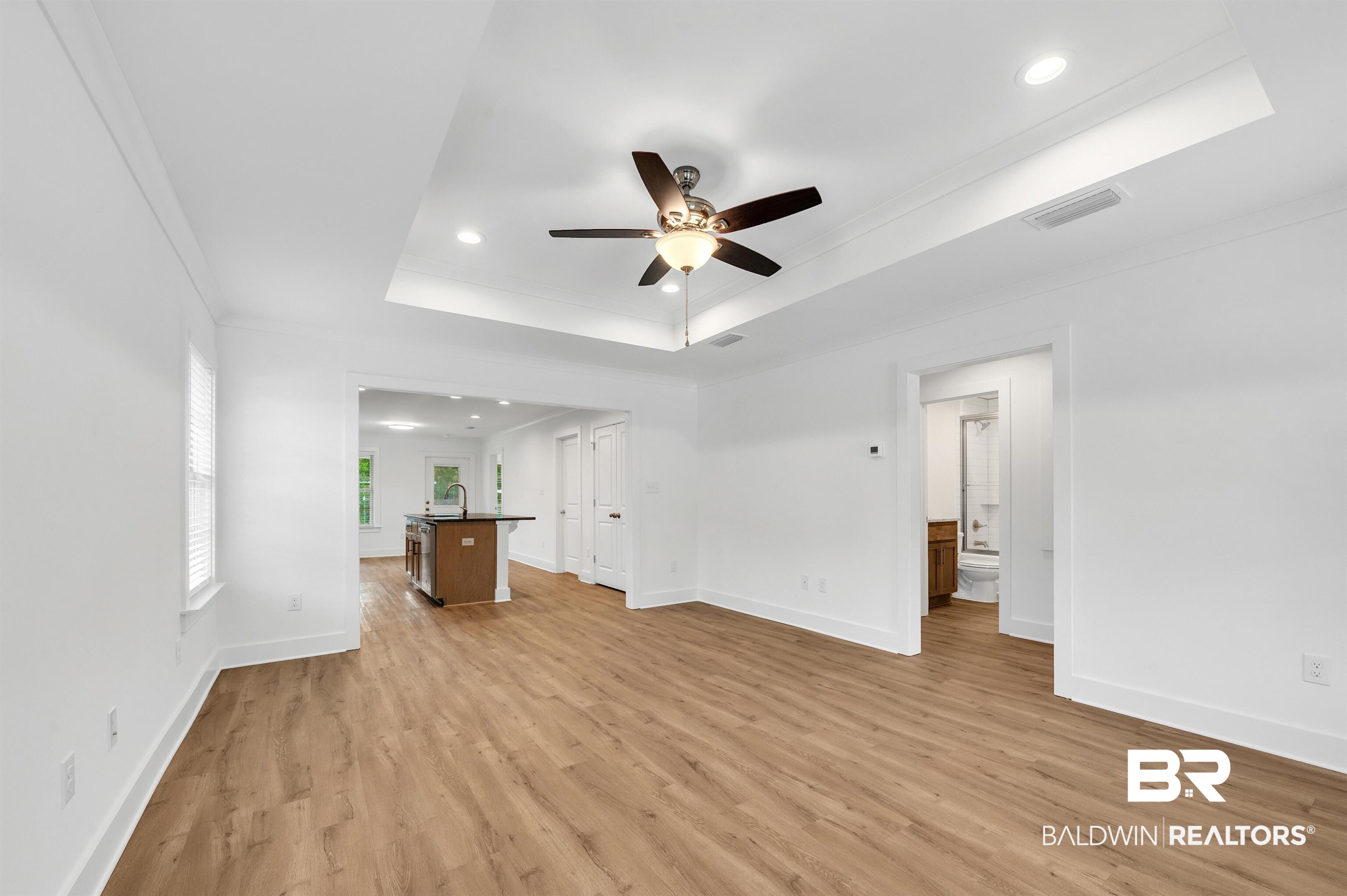 22045 8th Street Silverhill, AL 36576 - Photo 9 of 39 Living area room featuring a ceiling fan, a tray ceiling, light wood-style floors, recessed lighting, and baseboards