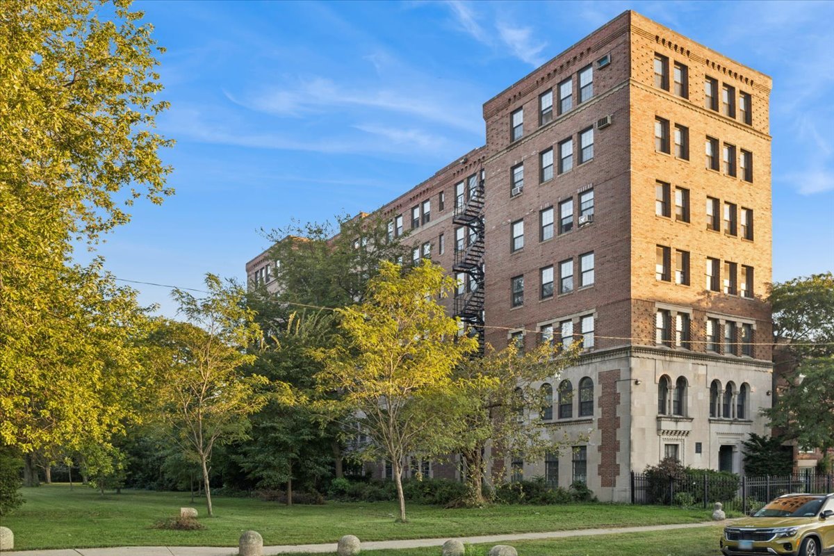 a view of a tall building next to a yard