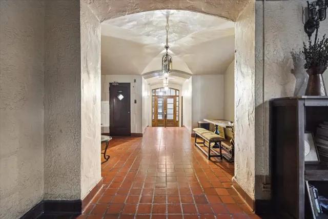 a hallway with a chandelier and wooden floor
