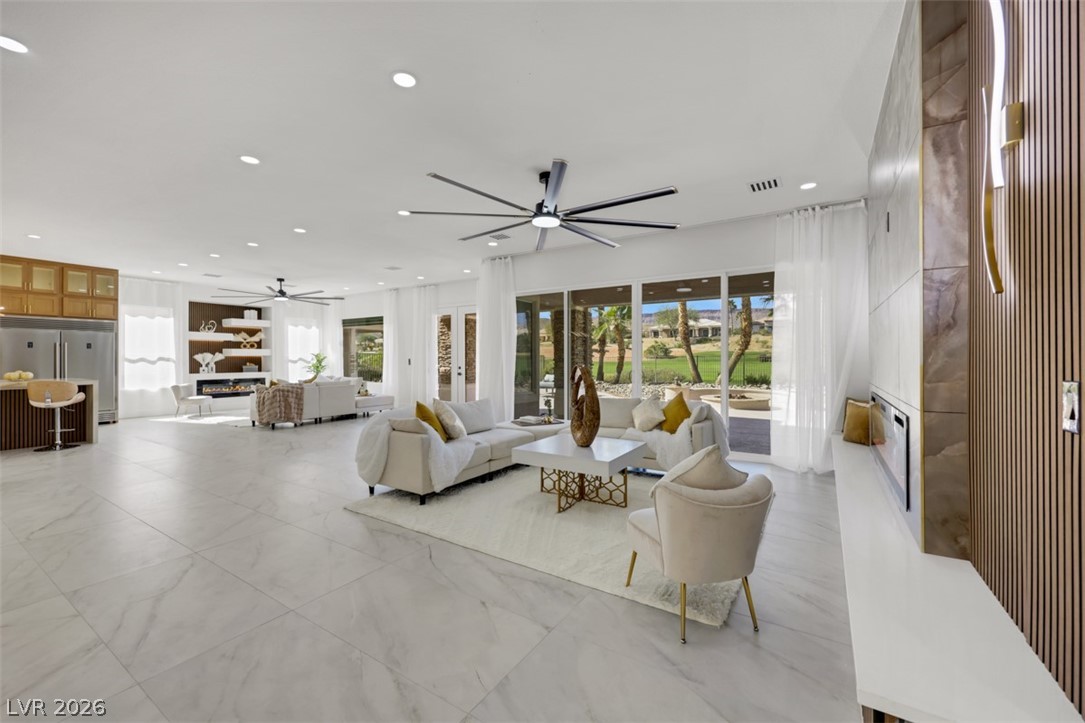 5015 Rivedro Street Las Vegas, NV 89135 - Photo 25 of 91 An open concept living area boasts a modern design with large sliding glass doors and golf course views.