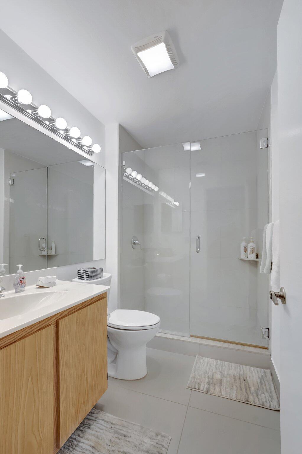 7950 La Mirada Drive Boca Raton, FL 33433 - Photo 27 of 42 a bathroom with a sink a toilet a mirror and shower