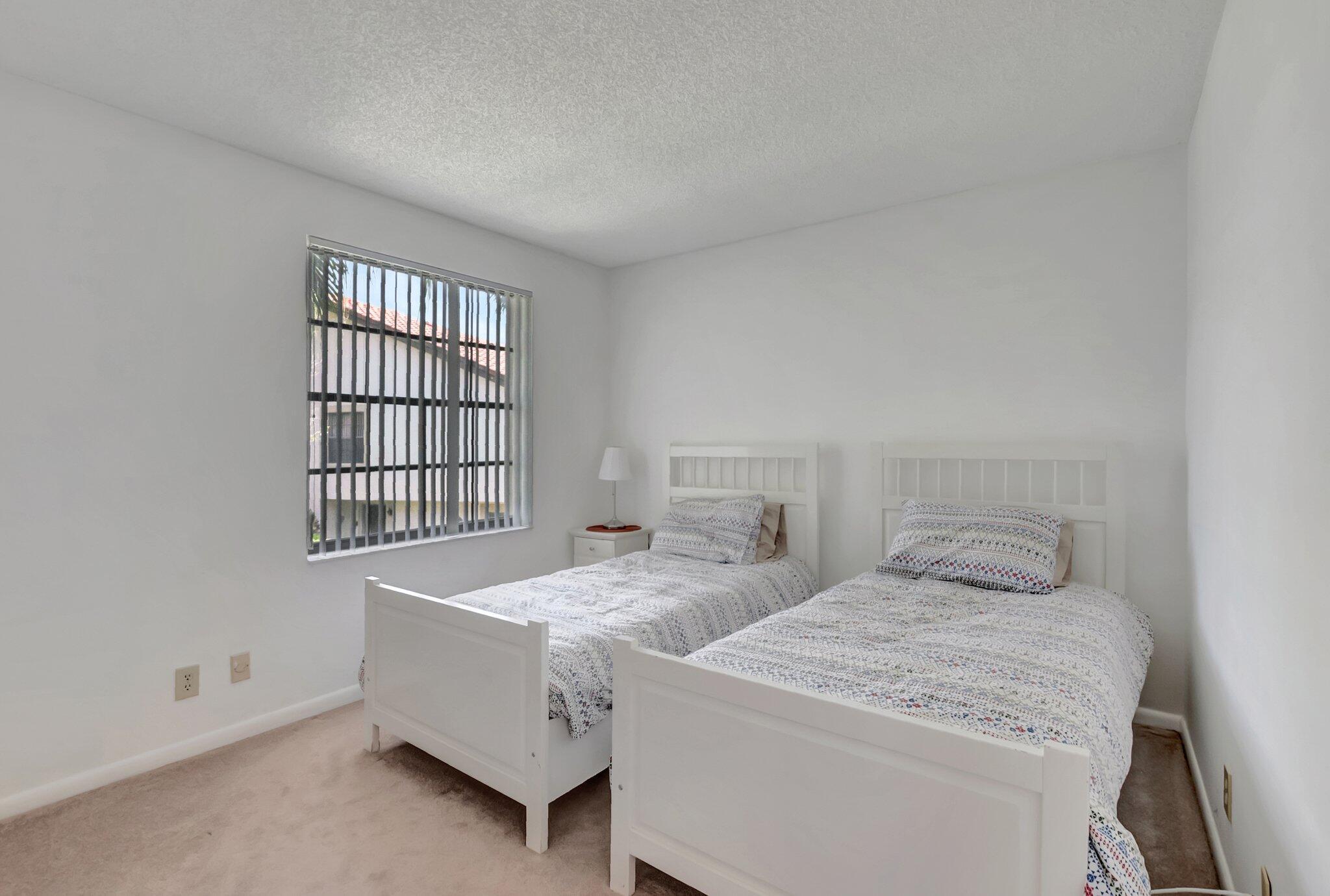 7950 La Mirada Drive Boca Raton, FL 33433 - Photo 28 of 42 a bedroom with two beds and a window