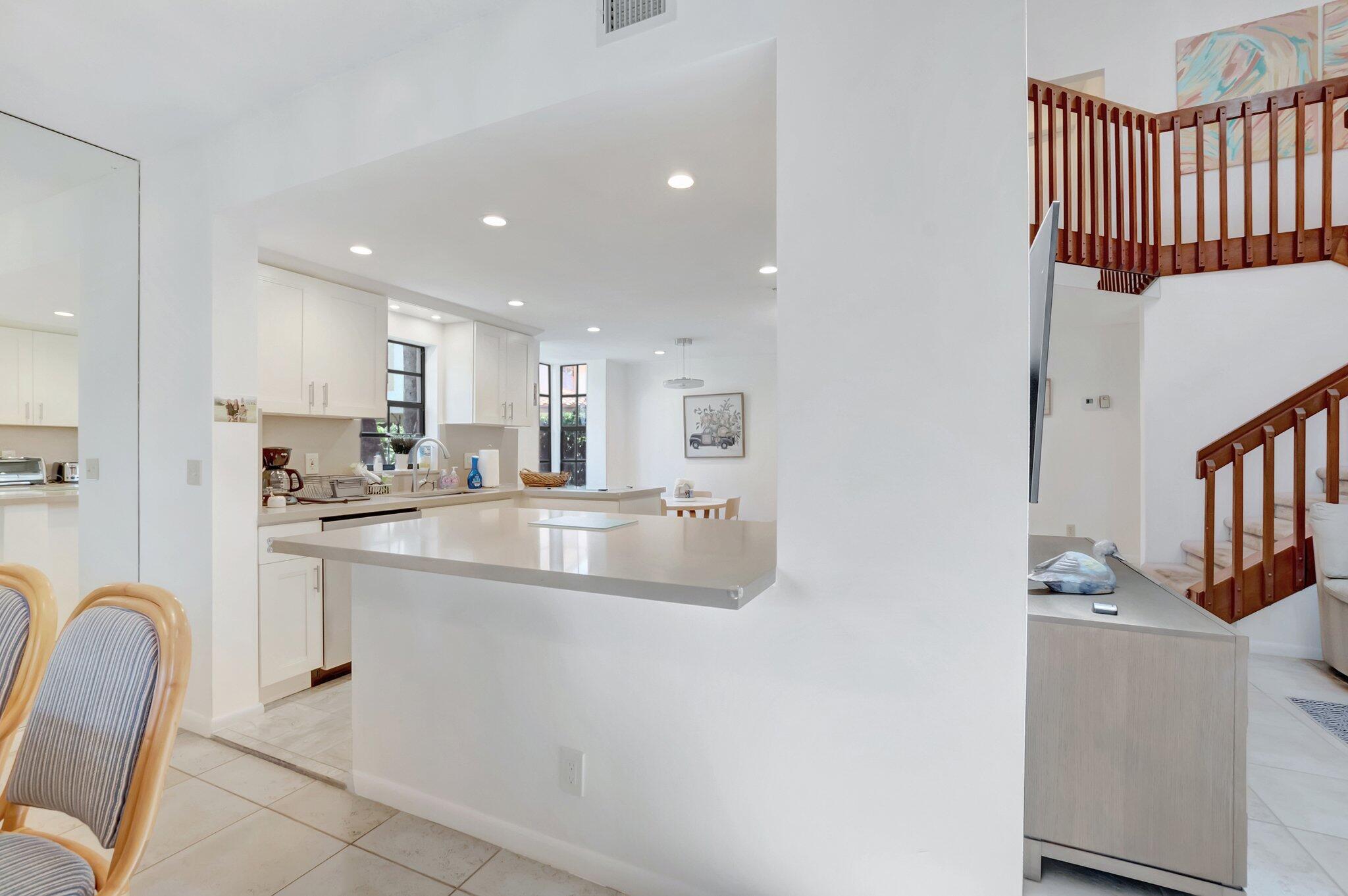 7950 La Mirada Drive Boca Raton, FL 33433 - Photo 10 of 42 a kitchen with stainless steel appliances granite countertop a sink and a refrigerator