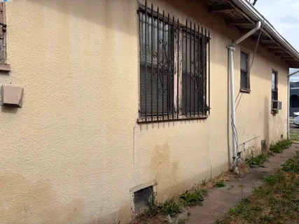 a backyard of a house with garden and parking