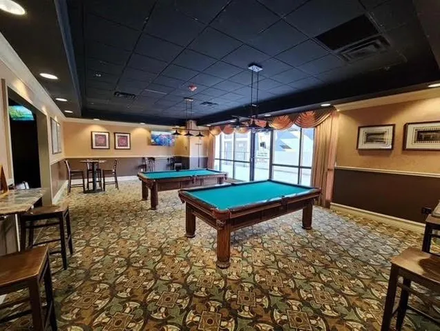 a living room with furniture a flat screen tv and a table